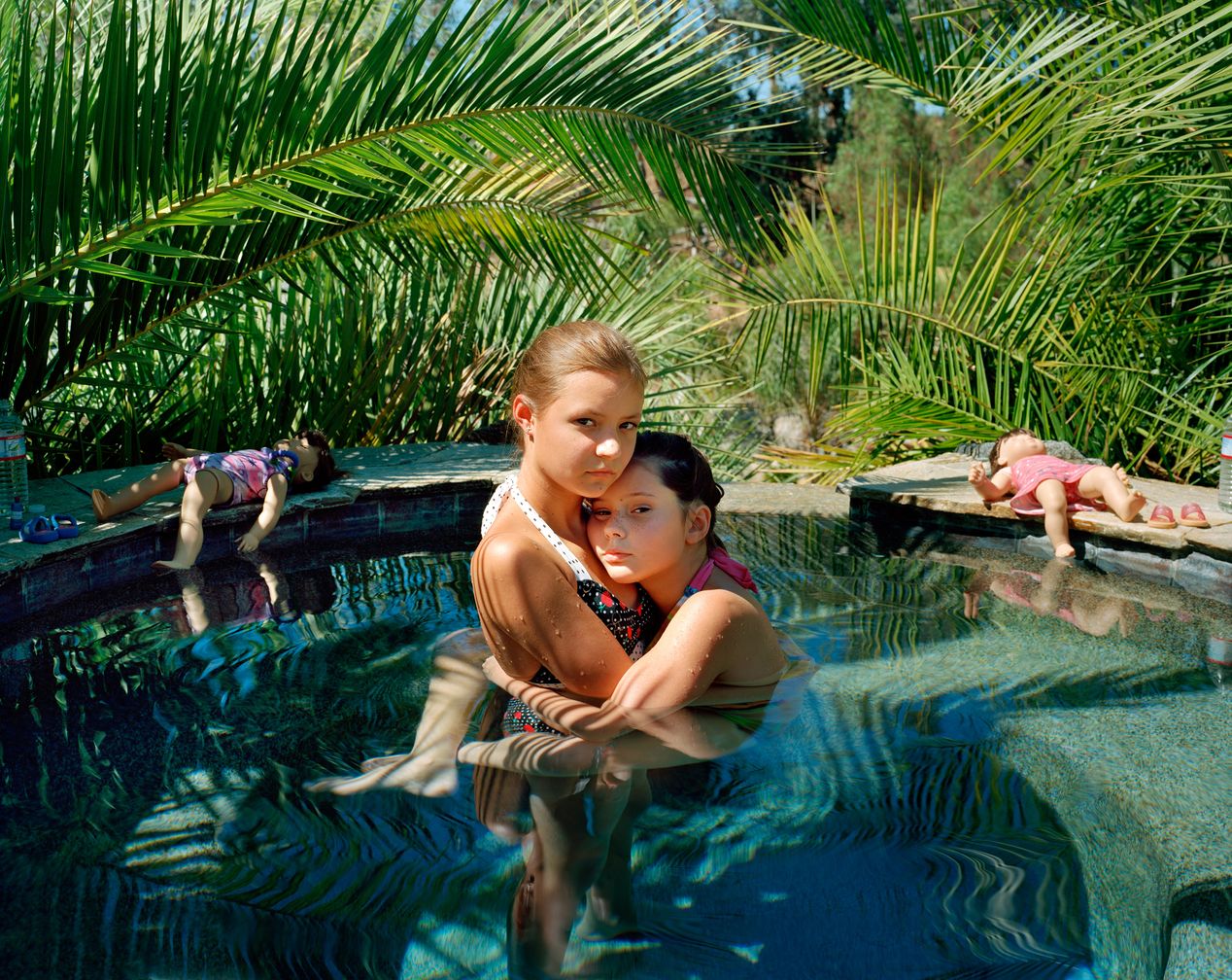Two sisters hugging in a small pool, environmental portrait photography, Ilona Szwarc, contemporary Los Angeles artist.