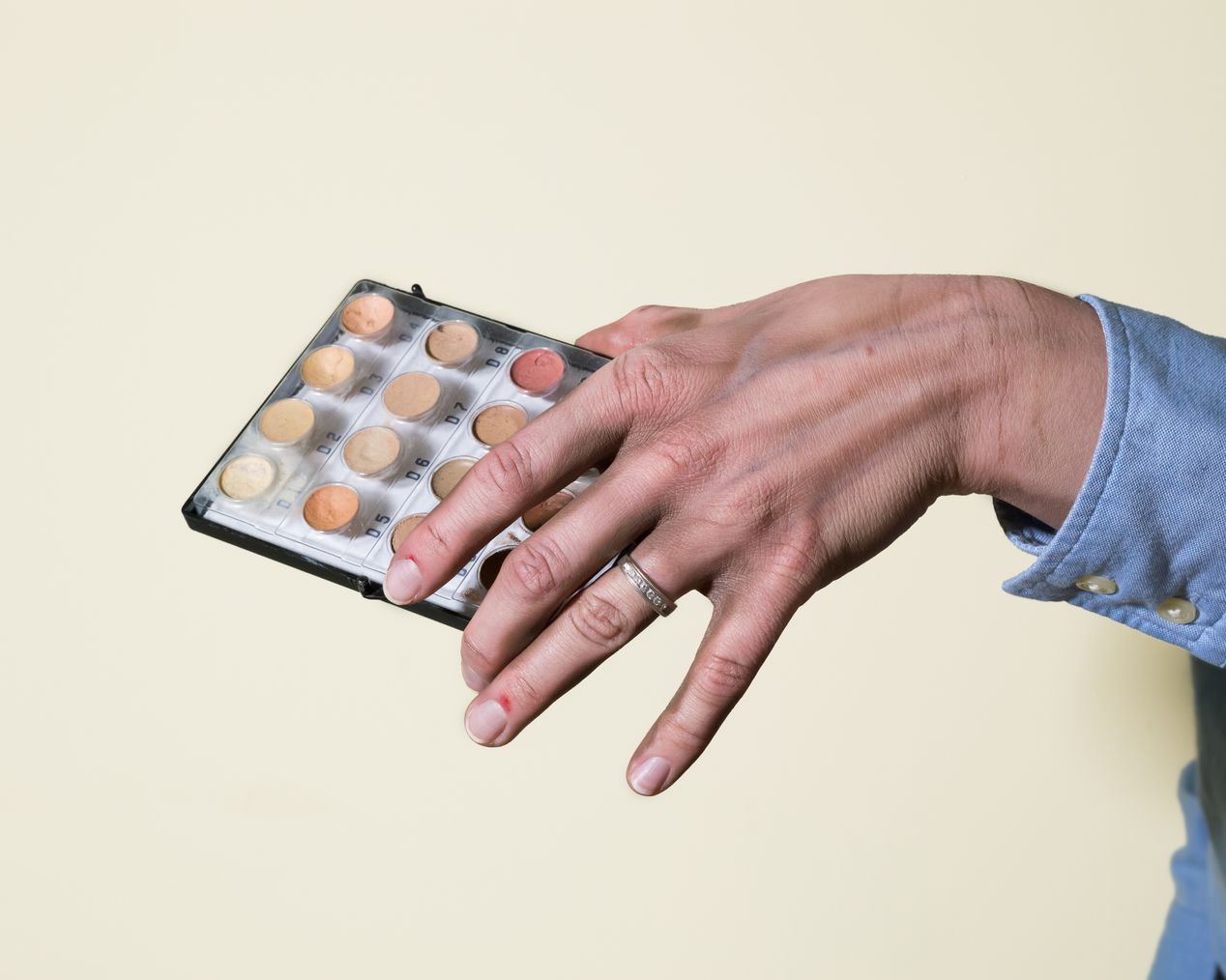 Makeup artist's hand holding a skin tone paint palette, art photography, Ilona Szwarc, contemporary Los Angeles artist.