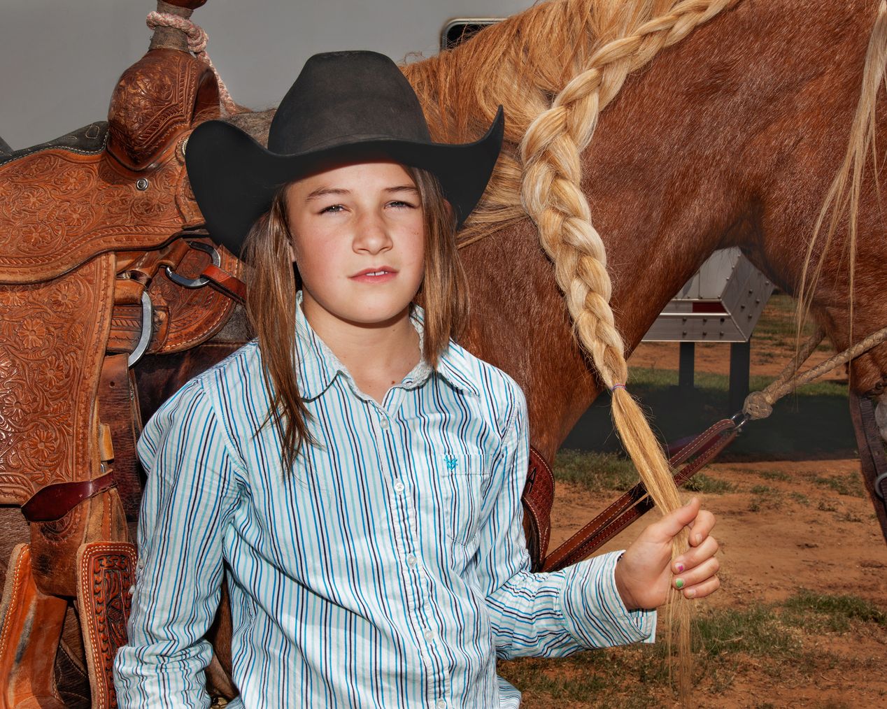 Young rodeo girl holding her braided horse's mane, environmental portrait photography, Ilona Szwarc, contemporary Los Angeles artist.